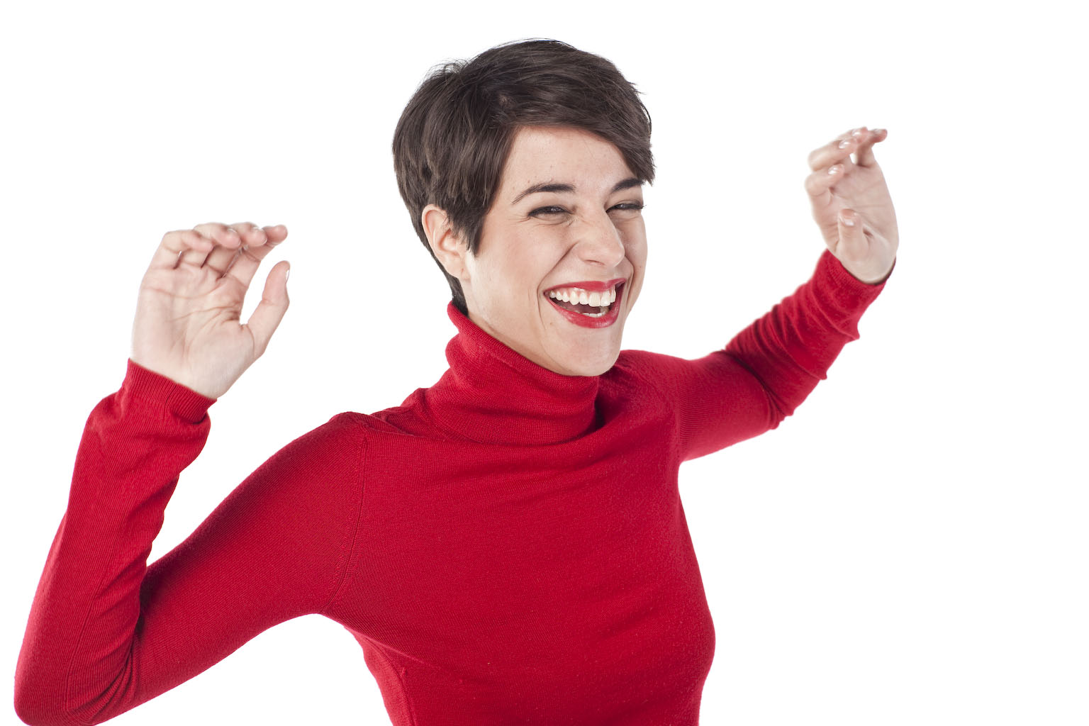 Smiling dancing woman with short brunette hair wearing red lipstick and a red jumper