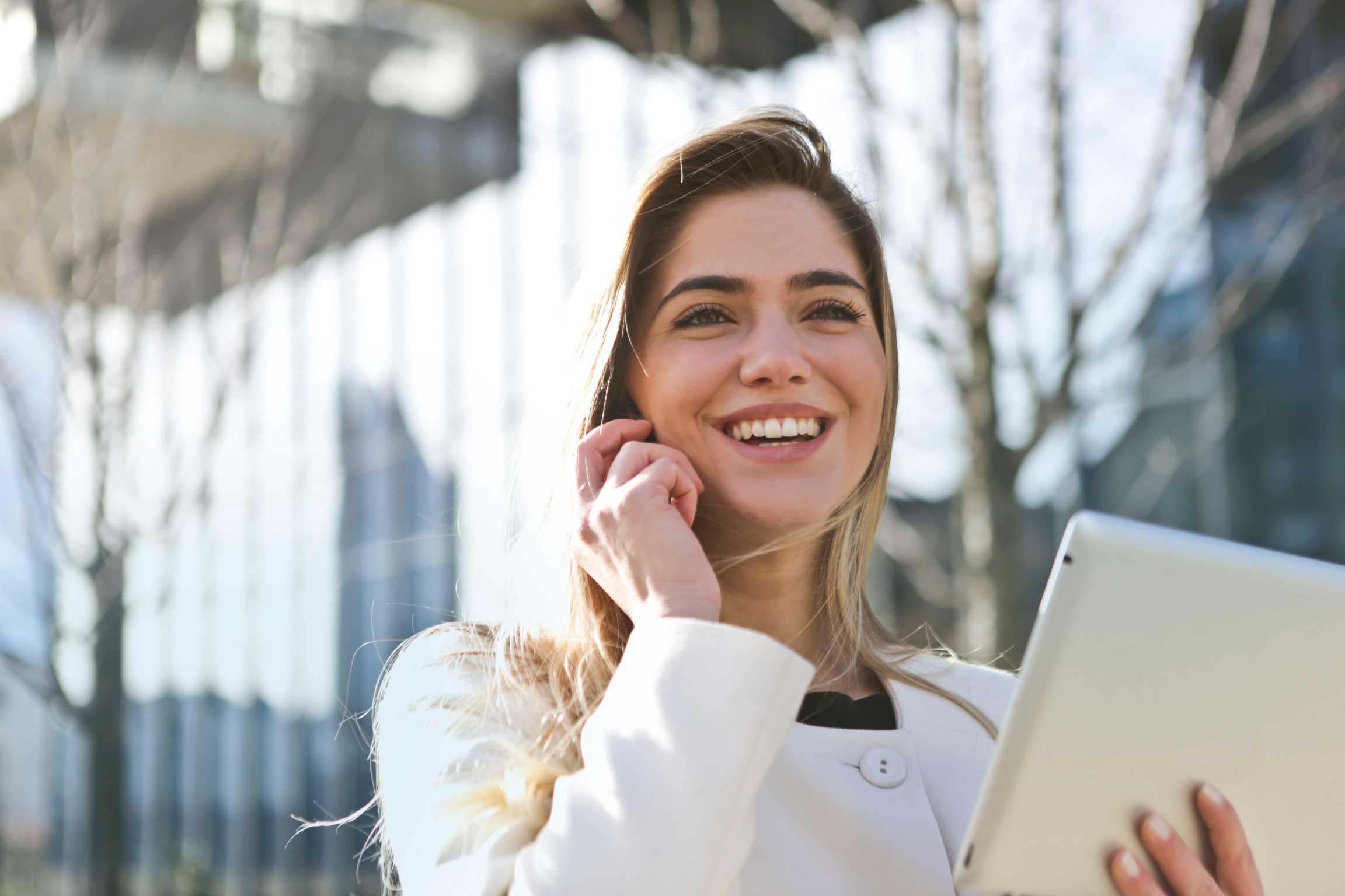 Smiling blonde woman with tablet in her hand