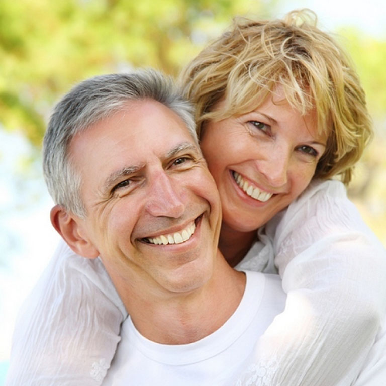 smiling older couple woman with arms around man